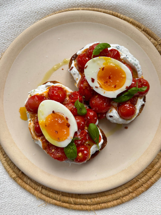 Toasts aux tomates cerises rôties, fromage aux herbes et œuf mollet