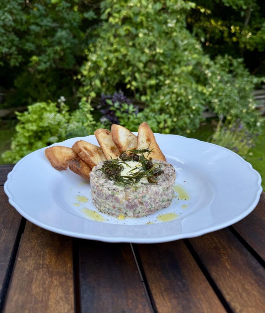 Tartare de boeuf et crostini maison dans une assiette blanche
